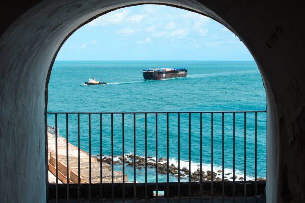 San Juan, Puerto Rico - April 20, 2017: A barge towed by a tugboat seen from Castillo San Cristobal.