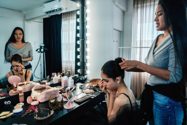 Makeup artist putting makeup on her young ballerina at the dance studio