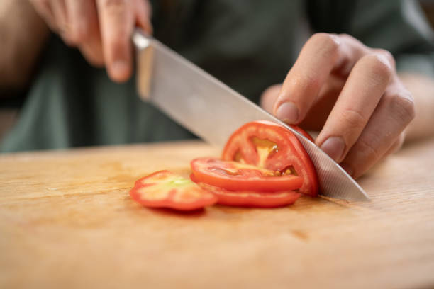 istock man cutting tomatoes with knife on cutting board in the kitchen 2177215131