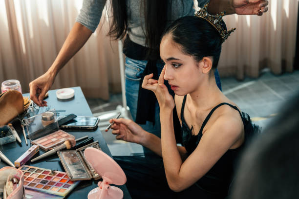 Close up of Cute Teenage girl ballet dancer applying make up for her dance performance at the dance studio