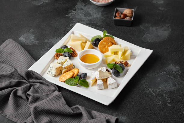 istock Elegant Cheese Platter with Grapes and Nuts on Dark Stone Background 2177218477