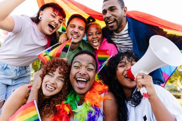 istock group of non-binary people multiracial diversity, demonstration lgbt concept. Diverse Group Celebrating at Pride Event with Rainbow Flags 2177219093