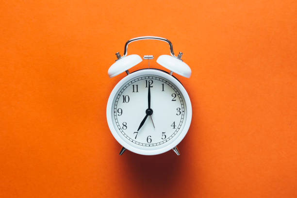 istock White vintage alarm clock on orange background, top view, flat lay. 2177220251