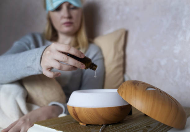istock A woman drops essential oils into a humidifier for a restful sleep. Relaxing effect of aromatherapy for anxiety and insomnia. Fighting sleep disorders 2177220661