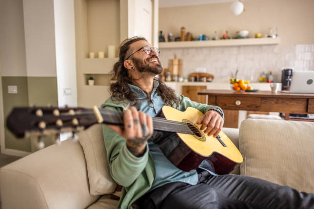 istock Man playing a guitar at home. 2177223716