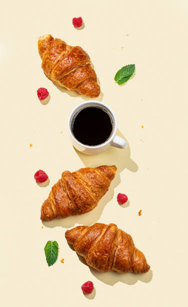 istock Flat lay of espresso coffee cup, fresh croissants, raspberry and mint leaf  on yellow background with shadow. 2177223916