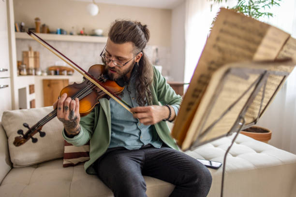 istock Man playing violin at home 2177224123
