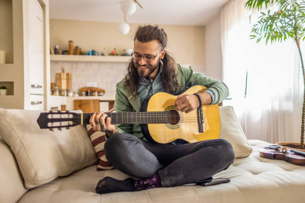 istock Man playing a guitar at home. 2177224376