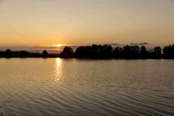 istock beautiful sunset with sun and orange sky on the lake 2177226820