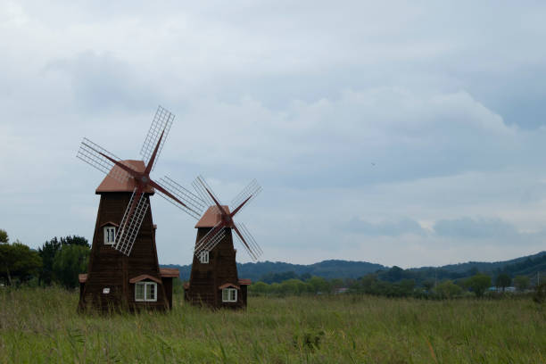 A windmill stands in a green meadow, swaying in the wind.    .
