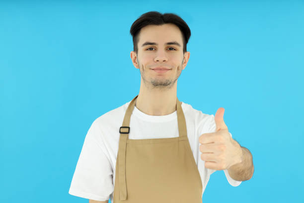 Concept of cooking, young man chef on blue background