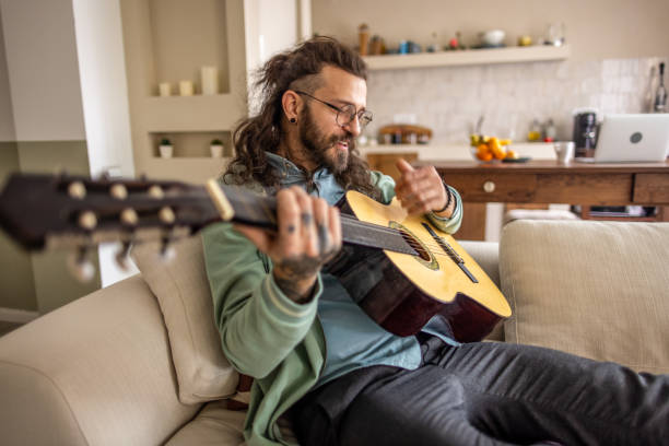istock Man playing a guitar at home. 2177229851