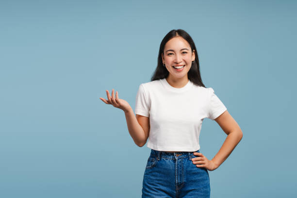 istock Smiling, attractive Asian woman showing something with hand, explaining isolated on blue background 2177231570