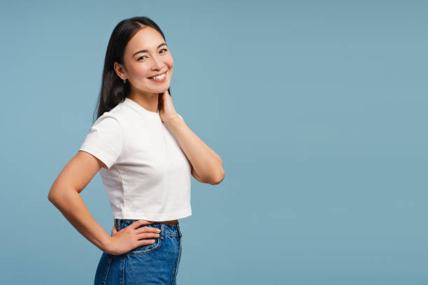 istock Smiling, attractive Asian woman looking at camera posing on blue background 2177231593