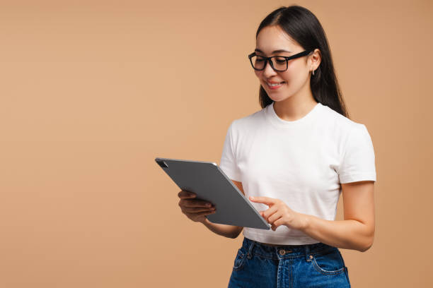 istock Smiling Asian woman browsing internet on digital tablet online technology and lifestyle concept 2177231662