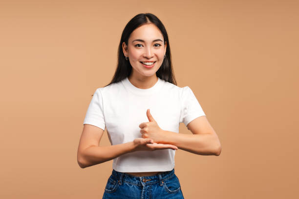 istock Smiling Asian woman gesturing with hand looking at camera isolated on beige background 2177231710