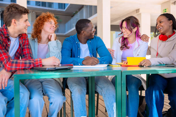 istock A group of students with laptops sit near the campus and communicate. 2177232042