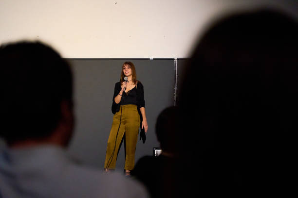 Female performer delivering a monologue on stage in an alternative theater with audience