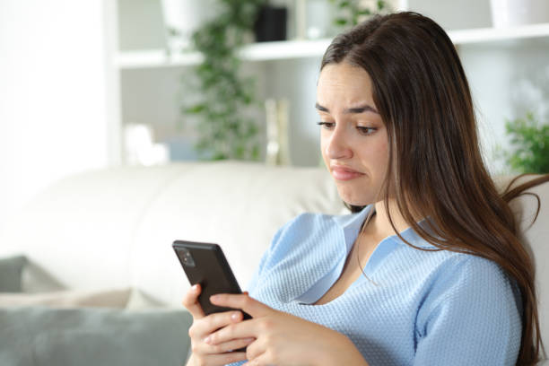 istock Disappointed woman is checking smart phone at home 2177237074