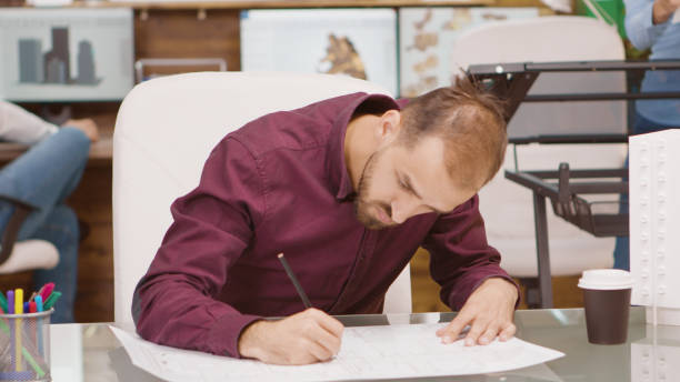 istock Bearded young architect drawing the project of a building 2177237222