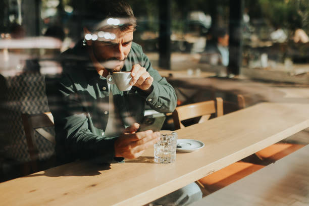 istock Toughtful man savoring coffee alone at a cozy cafe on a sunny day while lost in contemplation by the window 2177237947