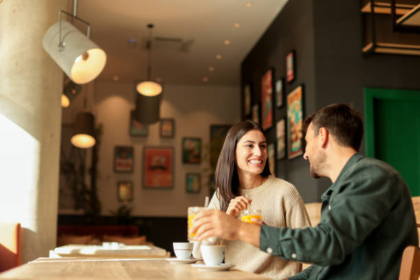 istock Couple enjoying at a cozy cafe with warm drinks and laughter in a vibrant, modern setting on a sunny afternoon 2177238834