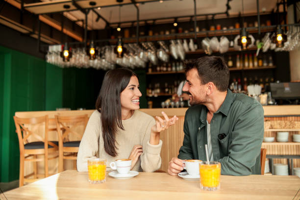 istock Couple enjoying at a cozy cafe with warm drinks and laughter in a vibrant, modern setting on a sunny afternoon 2177238857