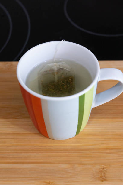 Cup of green tea with teabag on a wooden table