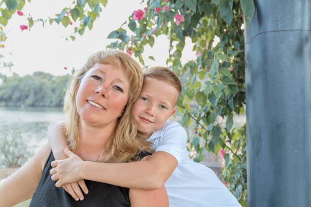 The son gives his mother a bouquet of flowers. A beautiful woman with her charming son. March 8, congratulations on international women's day, flowers, surprise