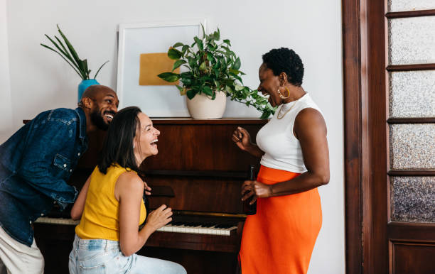 istock Diverse group of friends sharing laughter while playing the piano 2177244167