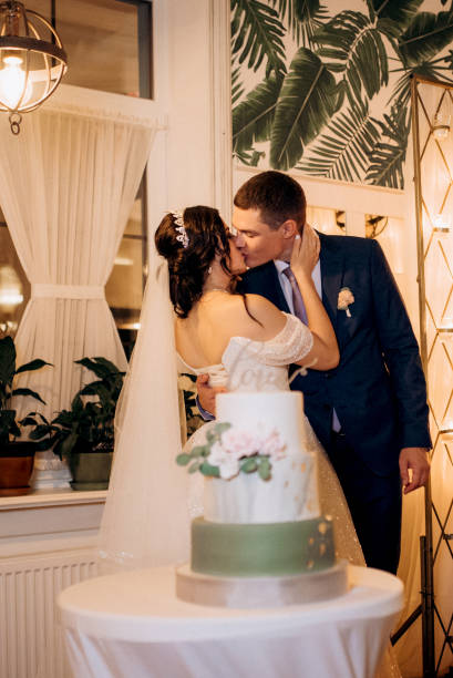 istock newlyweds happily cut and taste the wedding cake 2177244641