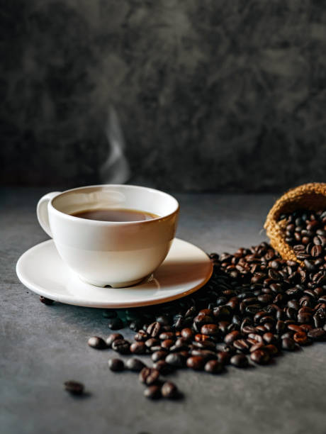 istock Americano coffee cup and roasted coffee beans falling in a burlap sackon gray background, Black coffee cup aromatic 2177246902