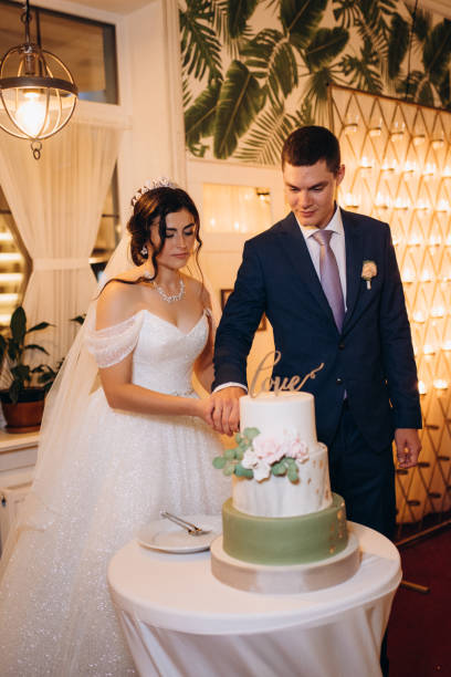 istock newlyweds happily cut and taste the wedding cake 2177247257