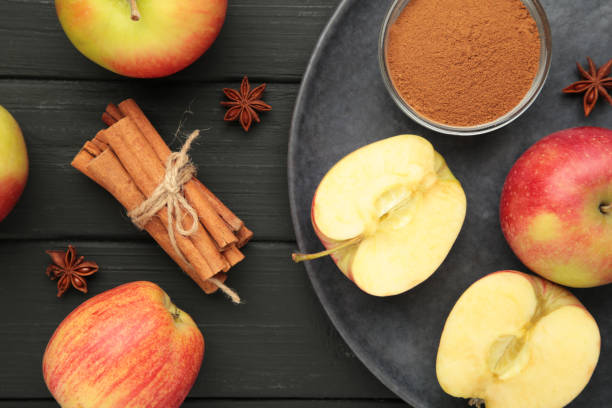 istock Red apple, apple slice and cinnamon sticks on dark background. 2177247576