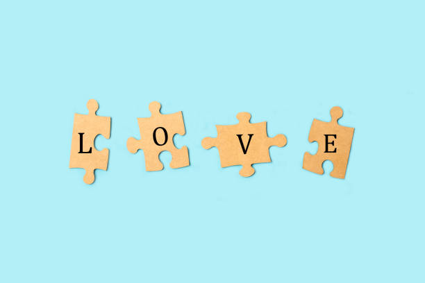 istock Love word written on brown puzzle pieces on a light blue background with copy space 2177248290