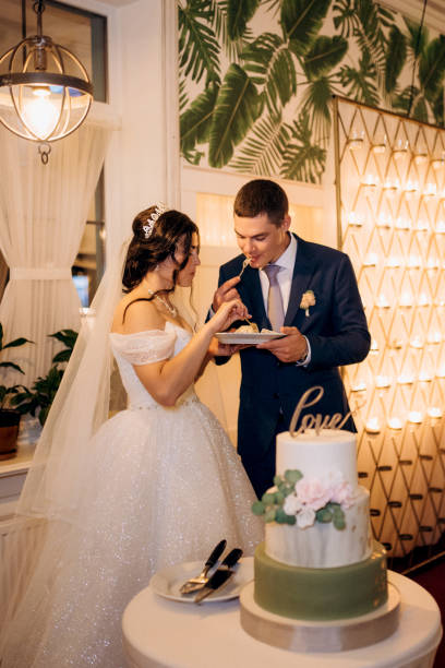 istock newlyweds happily cut and taste the wedding cake 2177253345