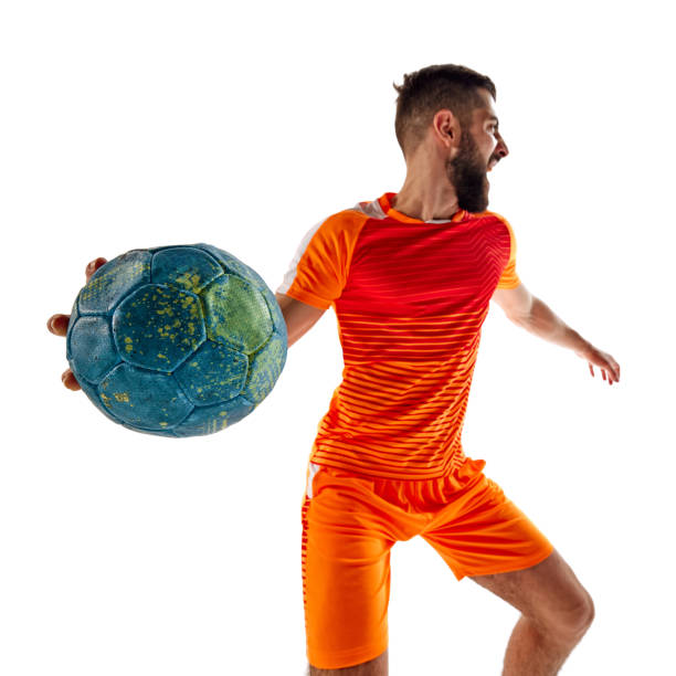 istock Dynamic image of young bearded man in orange uniform, handball player in motion, playing, training isolated on white background 2177255398