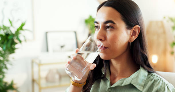 istock Woman, thinking and drinking with water in glass for hydration, cleanse or refreshment at office. Young, female person or employee with mineral liquid or beverage for thirst or natural sustainability 2177259904
