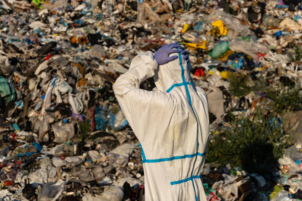 istock A worker in a protective suit surveys a vast landfill filled with discarded materials, highlighting the ongoing waste management issues affecting urban environments 2177260035