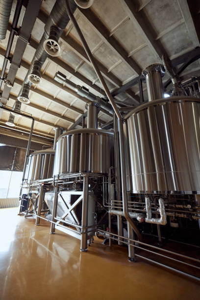 istock Large, modern brewery with several stainless steel fermentation tanks and pipes, connected by a network of pipes and valves. 2177261412