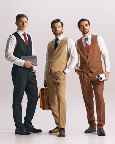 istock Dressed formally in vests,young men posing against white studio background showcase focus and professionalism. Corporate plans 2177264245