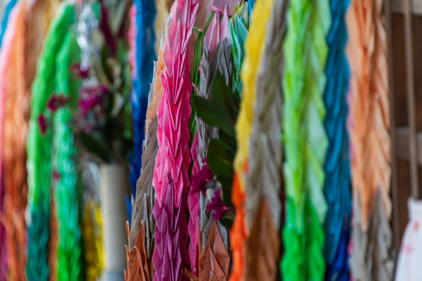 Hundreds of multi colored peace crane origami hanging close up.
