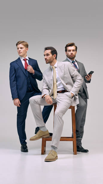istock Professionals posed in business suits, showcasing authority and executive presence with touch of casual posture against white background. 2177264807