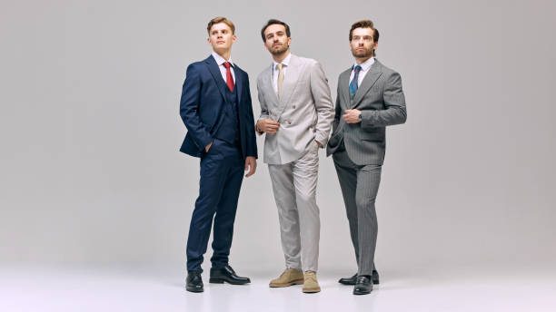 istock Three young man standing poised, each displaying individual style unified in professionalism against white studio background. 2177264814