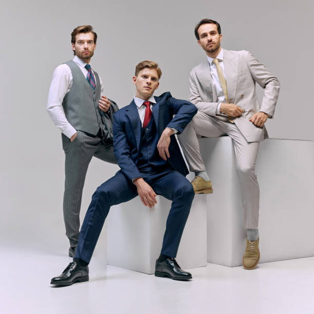 istock Seated executive, flanked by his colleagues, presenting mix of authority and teamwork against white studio background. 2177264815