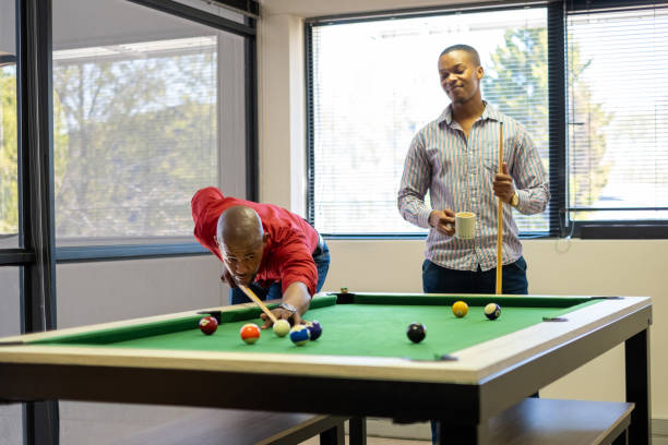 istock Two colleagues play a game of pool during a work break 2177264938