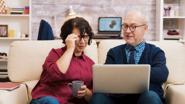 istock Happy senior middle aged couple sitting on sofa having a video call 2177266443
