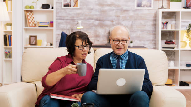 istock Elderly couple sitting on sofa using laptop for online shopping 2177266807