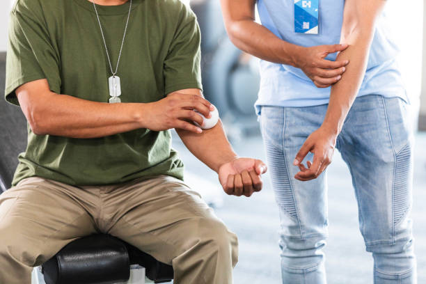 istock Unrecognizable male PT shows unrecognizable male soldier massage ball use 2177267686