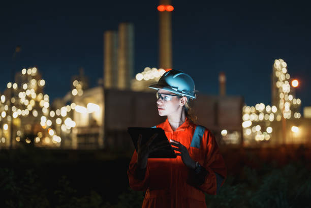 istock Female petroleum oil refinery engineer working with tablet to check safety quality control of oil and gas plant at night. 2177267872